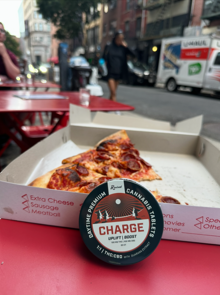 Revival Charge cannabis tablets on a pizza box in NYC — full-spectrum THC tablet made in Buffalo, NY for energy, focus, and daytime use.