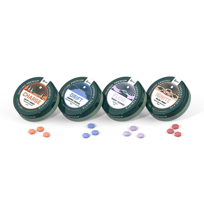 Four small round tins labeled Charge, Drift, Flow, and Ignite, each with colored tablets placed in front of them, matching their label designs.