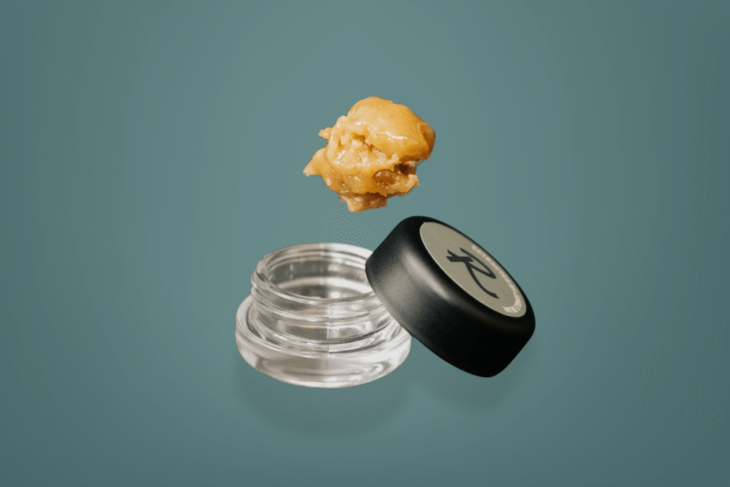 Close-up of Papaya Bomb Live Rosin by Revival:Farm.Lab.Market, tropical, solventless cannabis concentrate in a glass jar with a visible cold-cured texture.